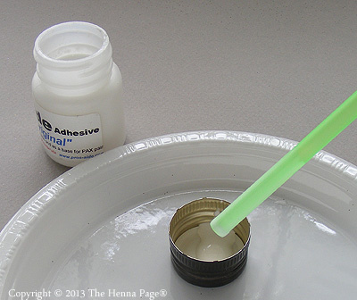 a few drops of 'white henna' in a cap